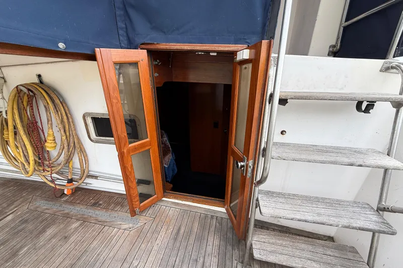 Qui-si-sana Yacht Photos Pics Entrance of 1989 Jefferson 52 Victory yacht with wooden door and coiled ropes.