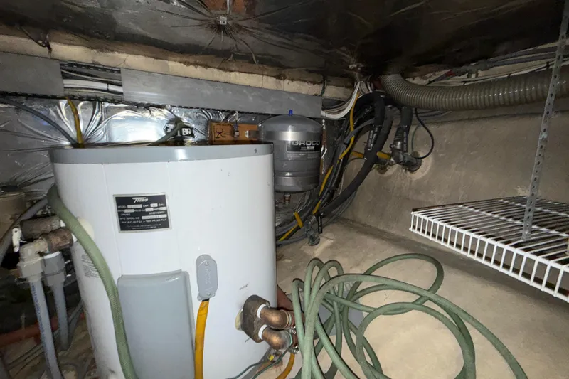 Qui-si-sana Yacht Photos Pics Basement utility area with water heater, pipes, and storage shelf; Jefferson 52 Victory, 1989.