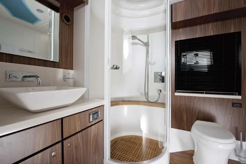  Yacht Photos Pics Luxurious bathroom in 2015 Fairline Squadron 78 yacht with modern fixtures and wood accents.