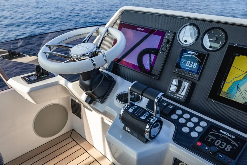 Jam Yacht Photos Pics Control panel of 2018 Sunseeker 74 Sport Yacht with navigation screens and steering wheel.