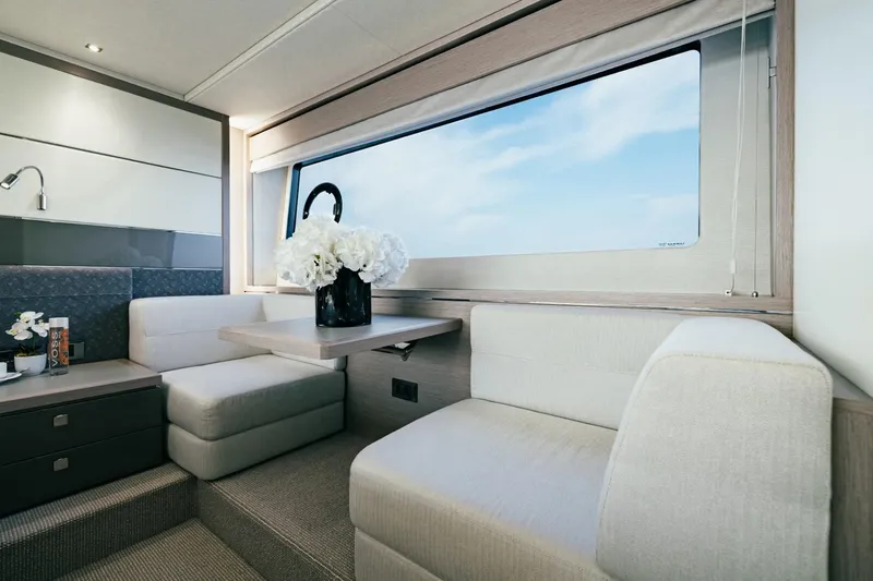 Jam Yacht Photos Pics Luxurious interior of 2018 Sunseeker 74 Sport Yacht with elegant seating and large window.