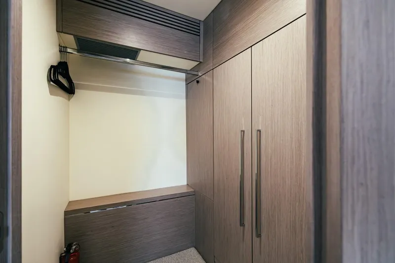 Jam Yacht Photos Pics Wooden closet interior on 2018 Sunseeker 74 Sport Yacht, featuring hangers and storage space.