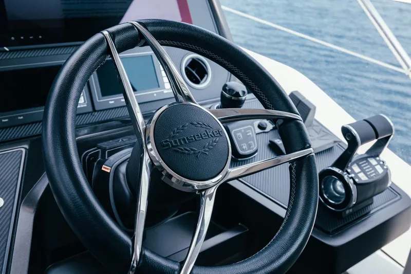 Jam Yacht Photos Pics Steering wheel of 2018 Sunseeker 74 Sport Yacht, featuring modern controls and ocean backdrop.