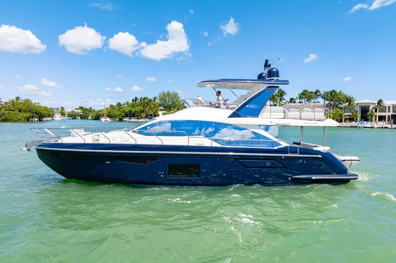  Yacht Photos Pics 2020 Azimut 60 Fly yacht cruising on clear blue water under a sunny sky.