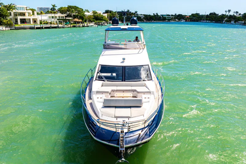  Yacht Photos Pics Azimut 60 Fly 2020 yacht cruising on turquoise waters near luxury waterfront homes.