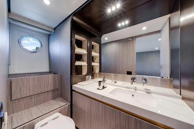  Yacht Photos Pics Luxurious bathroom interior of 2020 Azimut 60 Fly yacht with modern fixtures and porthole window.