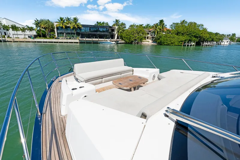  Yacht Photos Pics Luxurious Azimut 60 Fly yacht deck with seating, overlooking serene waterfront and lush greenery.