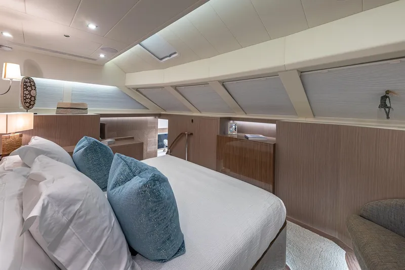 Oasis Yacht Photos Pics Luxurious 2023 Horizon PC60 yacht bedroom with elegant decor and plush blue pillows.