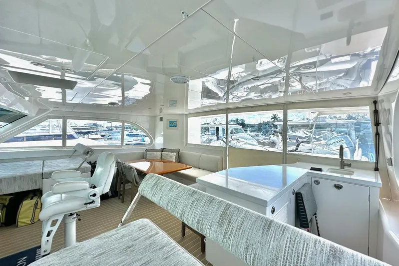Oasis Yacht Photos Pics Luxurious interior of 2023 Horizon PC60 yacht with modern seating and panoramic windows.