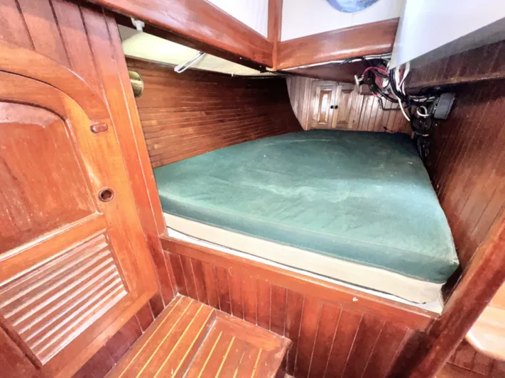  Yacht Photos Pics Cozy cabin interior of 1980 Hans Christian 38 MKII sailboat with wooden finish and green mattress.