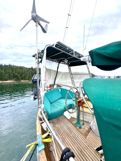  Yacht Photos Pics 1980 Hans Christian 38 MKII sailboat with green canopy and seating, docked near forested shoreline.