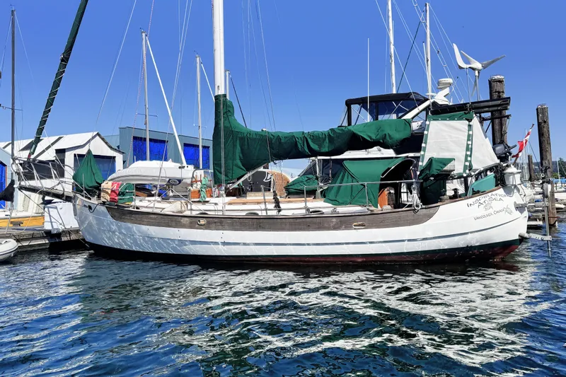  Yacht Photos Pics 1980 Hans Christian 38 MKII sailboat docked in a marina, featuring green covers.