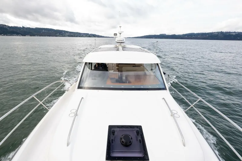 Ohana Yacht Photos Pics 2019 Nimbus 365 Coupe cruising on a serene lake with distant forested hills.