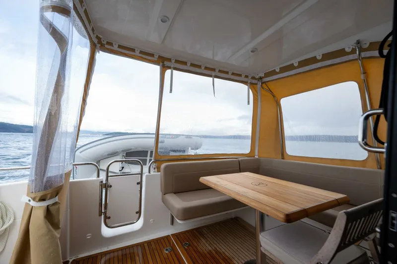 Ohana Yacht Photos Pics 2019 Nimbus 365 Coupe interior with wooden table, seating, and ocean view.