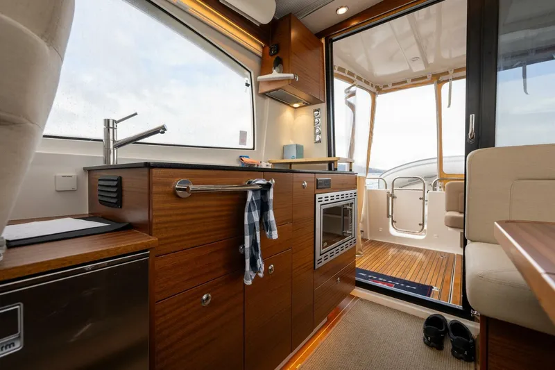 Ohana Yacht Photos Pics Interior of 2019 Nimbus 365 Coupe, featuring a modern kitchen with wood cabinetry.