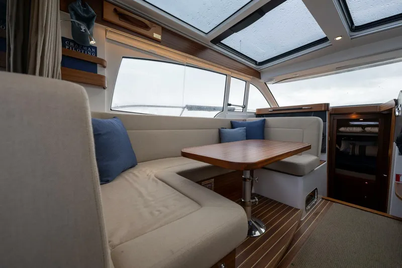 Ohana Yacht Photos Pics Interior of 2019 Nimbus 365 Coupe with cozy seating and wooden table.