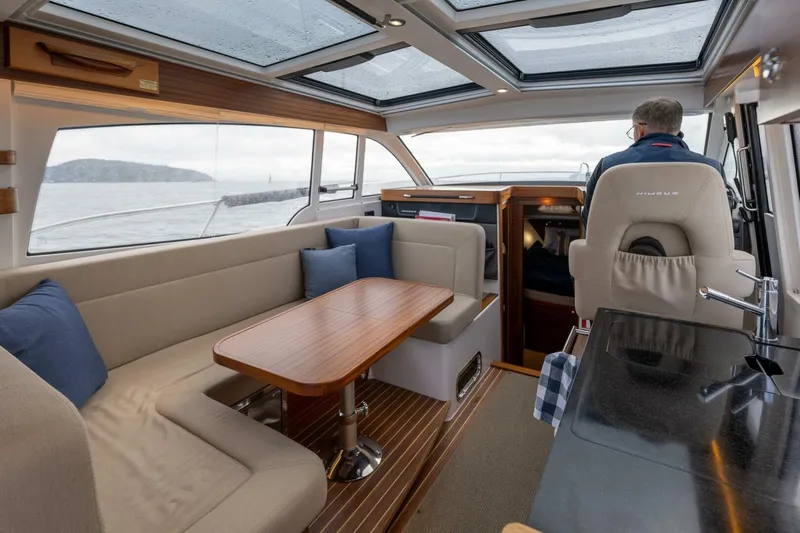 Ohana Yacht Photos Pics Interior of 2019 Nimbus 365 Coupe yacht with seating and helm, featuring panoramic windows.