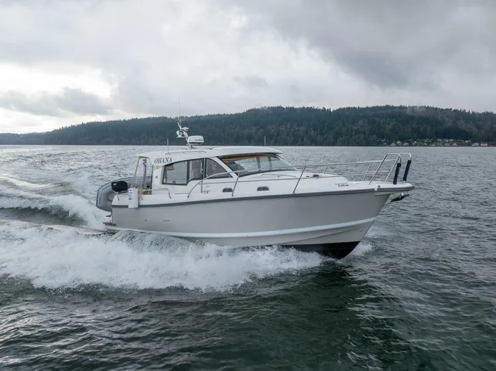 Ohana Yacht Photos Pics 2019 Nimbus 365 Coupe cruising on a lake under cloudy skies.