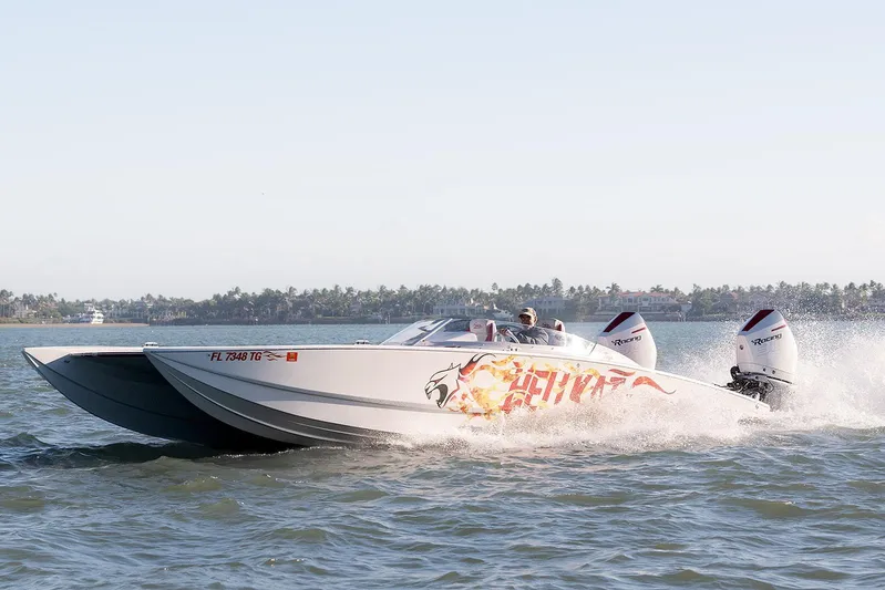  Yacht Photos Pics 2022 HellKats 32 powerboat speeding on water with twin engines, vibrant graphics.