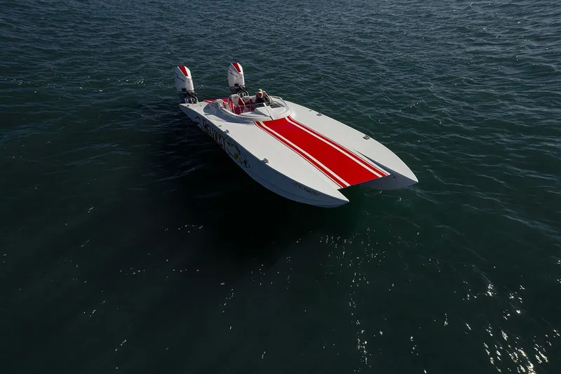  Yacht Photos Pics 2022 HellKats 32 powerboat with red stripe, cruising on open water.