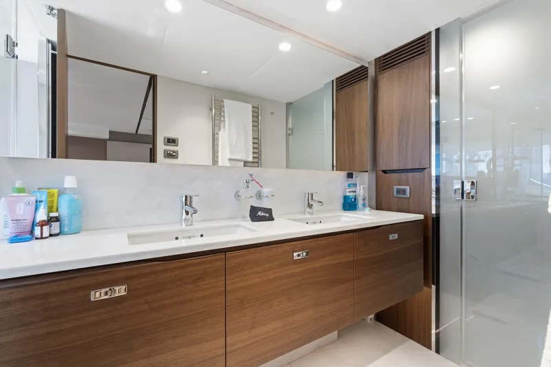  Yacht Photos Pics Luxurious bathroom in 2022 Princess Y85 yacht with modern fixtures and wooden cabinetry.