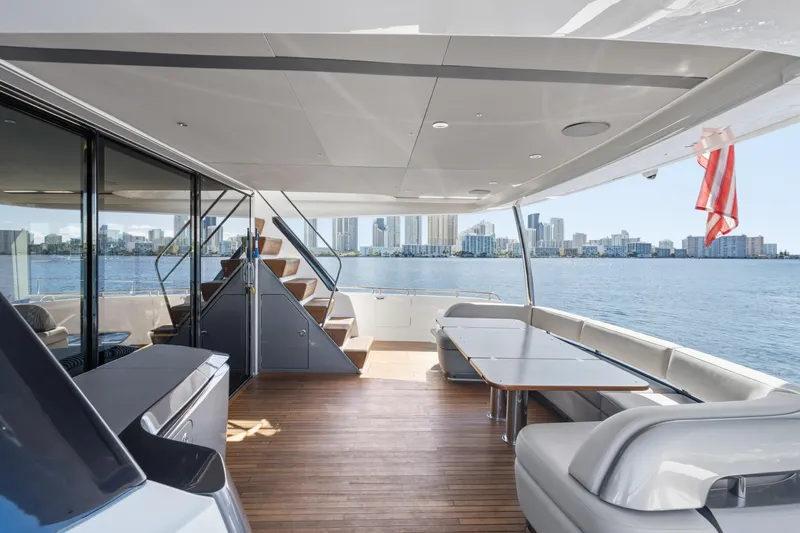 Yacht Photos Pics Luxurious 2022 Princess Y85 yacht deck with city skyline view, featuring elegant seating and dining area.