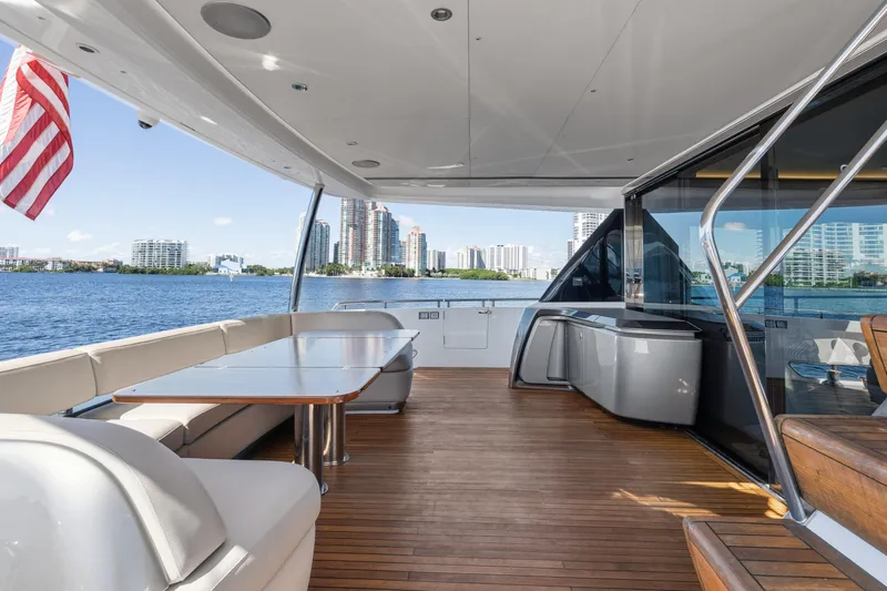  Yacht Photos Pics Luxurious 2022 Princess Y85 yacht deck with seating, table, and scenic waterfront view.