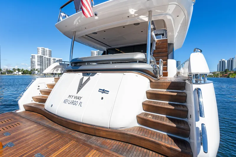  Yacht Photos Pics Luxury Princess Y85 yacht, 2022 model, docked with elegant wooden steps and city skyline backdrop.