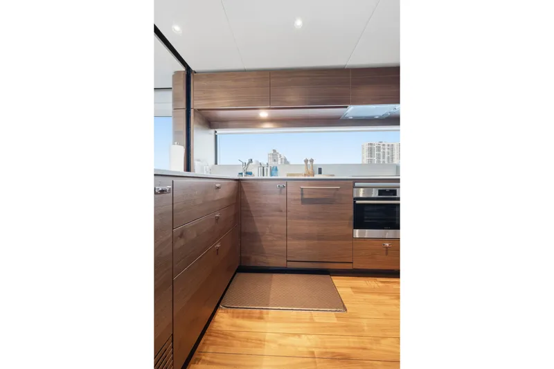  Yacht Photos Pics Luxurious kitchen interior on 2022 Princess Y85 yacht, featuring sleek wooden cabinetry and modern appliances.