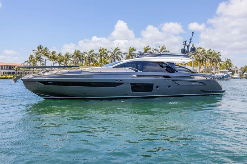No Time To Die Yacht Photos Pics 2023 Azimut S8 yacht cruising on clear blue water with palm trees in the background.