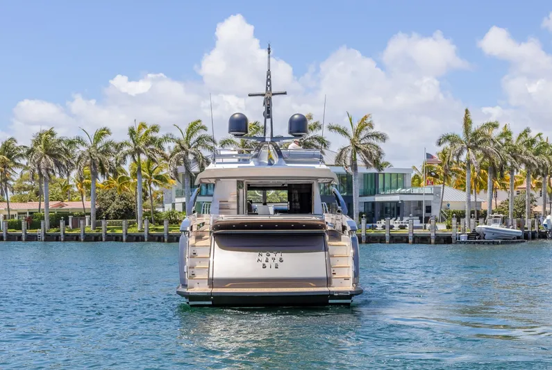 No Time To Die Yacht Photos Pics 2023 Azimut S8 yacht on water, surrounded by palm trees and luxury waterfront homes.