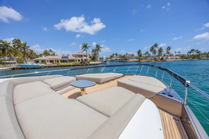 No Time To Die Yacht Photos Pics Luxurious 2023 Azimut S8 yacht deck with plush seating, overlooking tropical waterfront scenery.