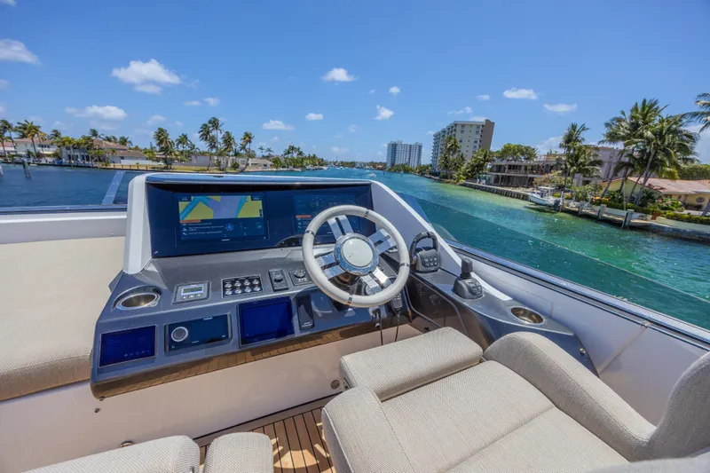 No Time To Die Yacht Photos Pics 2023 Azimut S8 yacht helm with modern controls, cruising on a sunny waterway.