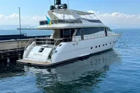 Luxury 2004 Leopard 26 Flybridge yacht docked by the shore on a sunny day.