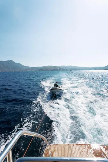  Yacht Photos Pics Leopard 26 Flybridge 2004 towing a small boat on open sea.
