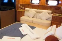 Luxurious interior of a 2004 Leopard 26 Flybridge yacht with elegant bedding and ambient lighting.