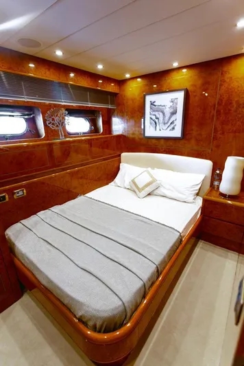  Yacht Photos Pics Luxurious bedroom in a 2004 Leopard 26 Flybridge yacht with elegant wood paneling.