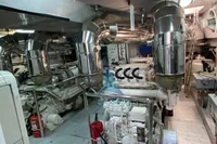 Engine room of a 2004 Leopard 26 Flybridge yacht, featuring dual engines and polished exhaust systems.