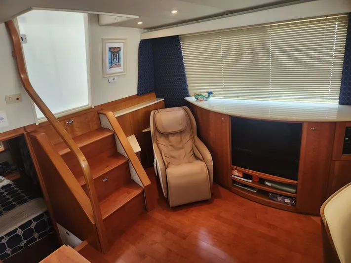 Nacho Boat Yacht Photos Pics Interior of 2001 Silverton 453 Motor Yacht with wooden stairs, recliner, and entertainment center.