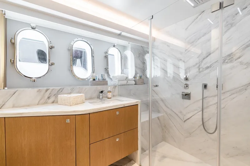 Jasmine Luna Yacht Photos Pics Luxurious yacht bathroom with marble shower, wooden cabinets, and porthole windows on Moonen JASMINE LUNA 2007.