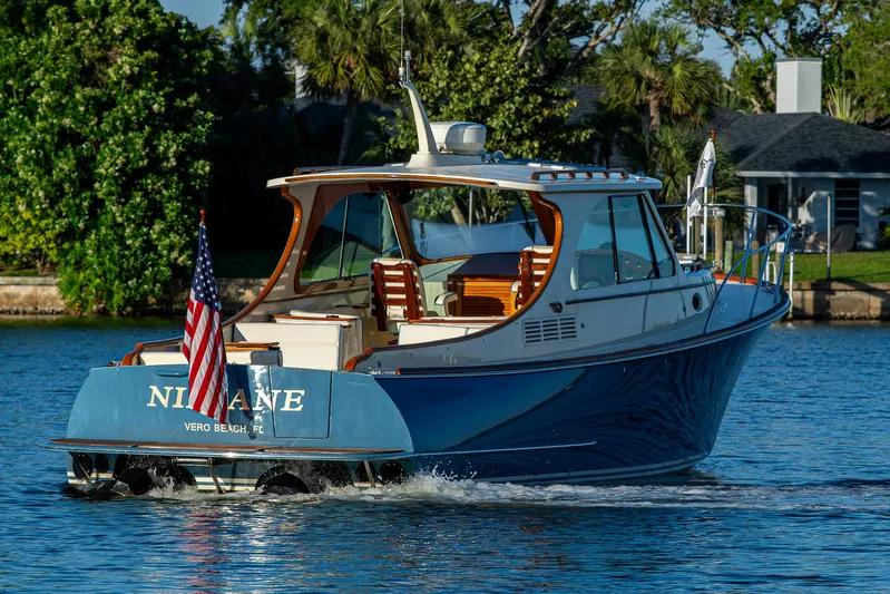 Niniane Yacht Photos Pics 2016 Hinckley Talaria 34 cruising on a serene waterway, displaying an American flag.