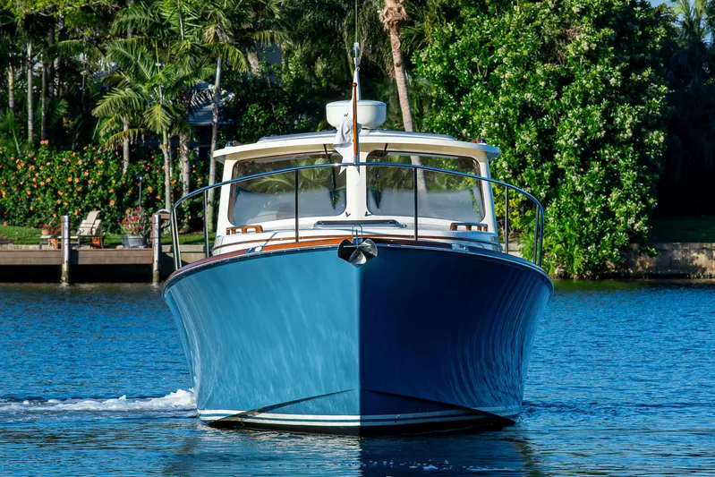 Niniane Yacht Photos Pics 2016 Hinckley Talaria 34 boat on water, surrounded by lush greenery.