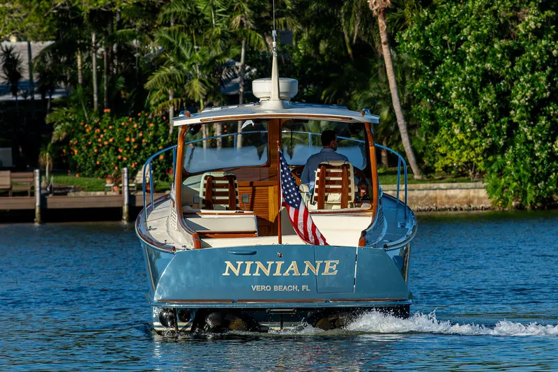 Niniane Yacht Photos Pics 2016 Hinckley Talaria 34 cruising on a scenic waterway with lush greenery.