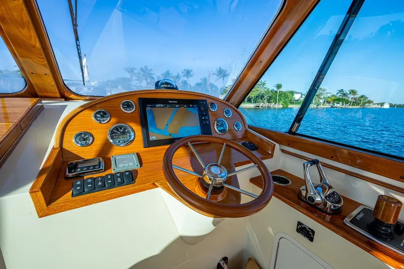 Niniane Yacht Photos Pics Helm of 2016 Hinckley Talaria 34 yacht with wooden steering wheel and navigation instruments.