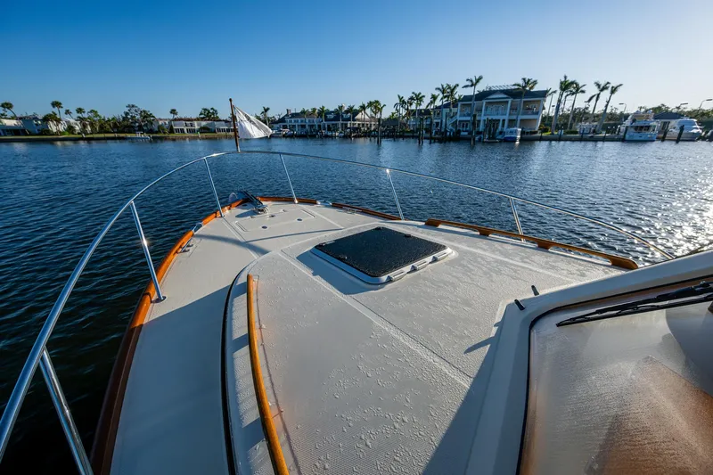 Niniane Yacht Photos Pics 2016 Hinckley Talaria 34 yacht on calm water with scenic waterfront view.