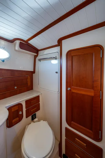 Niniane Yacht Photos Pics 2016 Hinckley Talaria 34 yacht bathroom with wooden cabinetry and white fixtures.