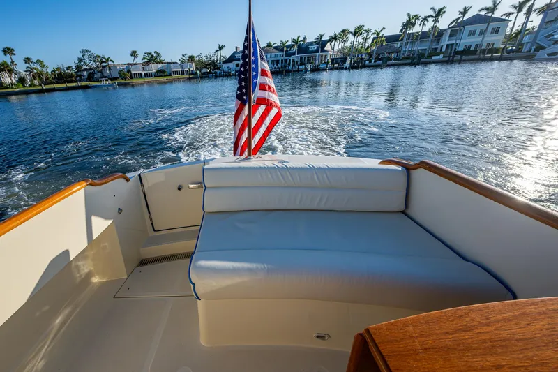 Niniane Yacht Photos Pics Hinckley Talaria 34 boat, 2016 model, with American flag, cruising on a sunny day.