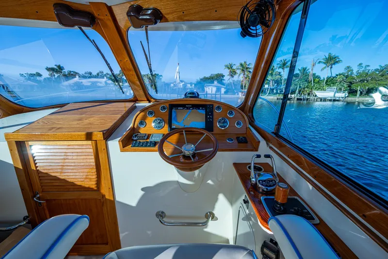Niniane Yacht Photos Pics 2016 Hinckley Talaria 34 yacht cockpit with wooden dashboard and scenic water view.
