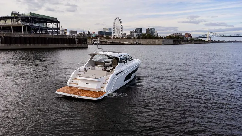  Yacht Photos Pics 2025 Azimut Atlantis 45 yacht cruising near urban waterfront with Ferris wheel in background.