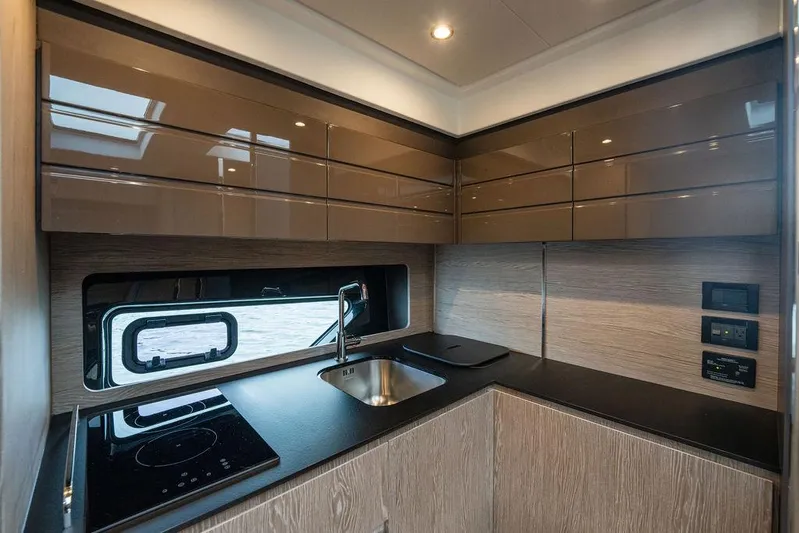  Yacht Photos Pics Modern kitchen interior of 2025 Azimut Atlantis 45 yacht with sleek cabinetry and appliances.